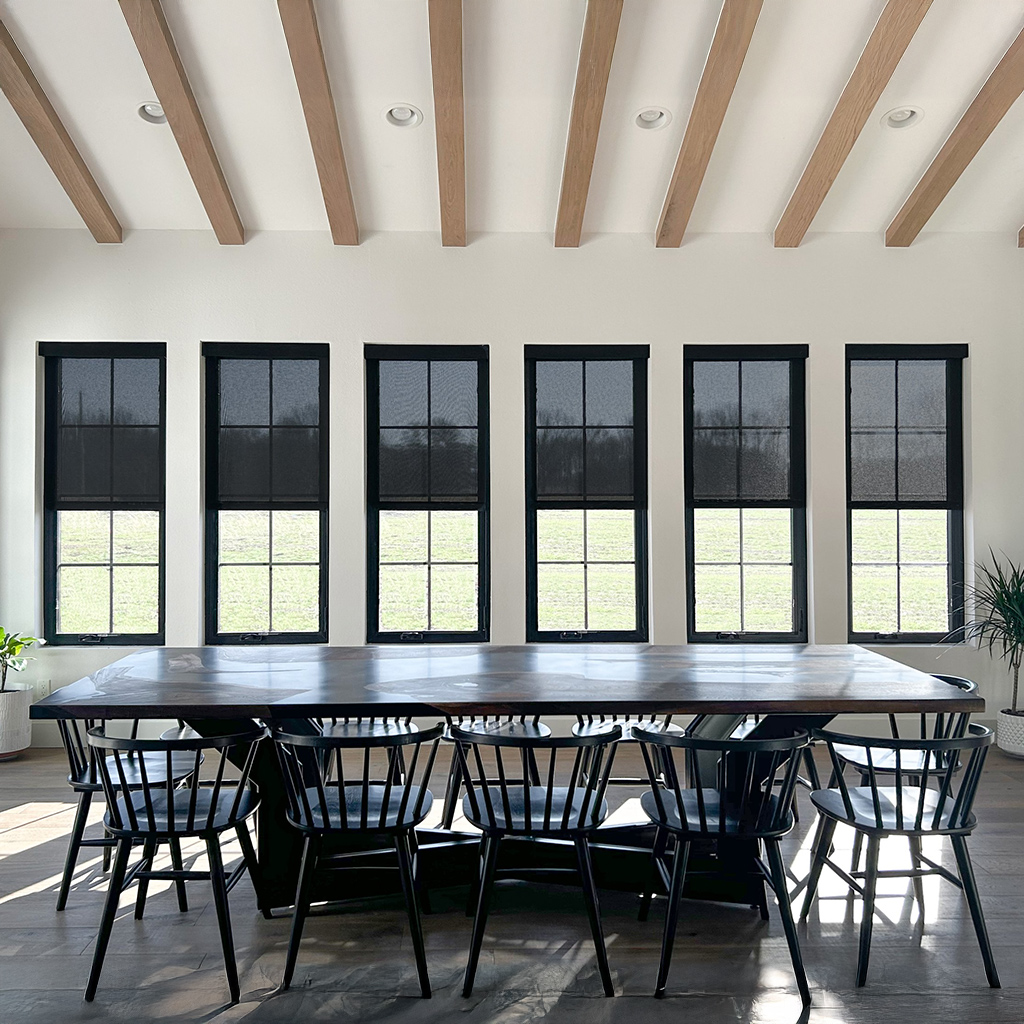smart-shades_automatic-window-shades_black-fascia-dining-room1 A black large family dinner table with a backdrop of Automatic Window Shades known as Smart Shades by Ridgeline. Ridgeline Roofing and Solar is a proud Powershades dealer.